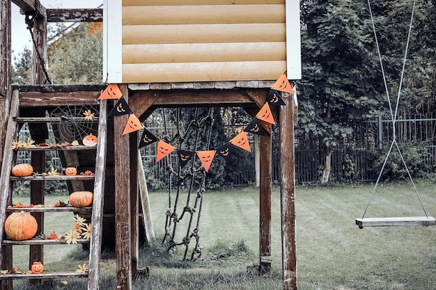 Patio de diseño de Halloween con hojas secas de otoño Hermoso porche de madera de la casa con calabazas en otoño