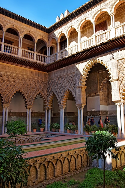 Pátio do Royal Alcazar Place em Sevilha, Andaluzia, Espanha. Pessoas no fundo