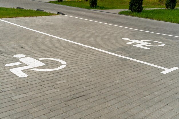 El patio de un gran complejo residencial de varias plantas en verano con plazas de aparcamiento para coches Plazas de aparcamiento para conductores con discapacidad