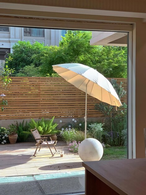 Un patio con mesa y sillas y una mesa con una sombrilla blanca.