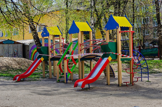 El patio de recreo está rodeado por una cinta prohibida. Lugares cerrados para juegos al aire libre debido a la cuarentena debido a la pandemia de coronovirus (epidemia)