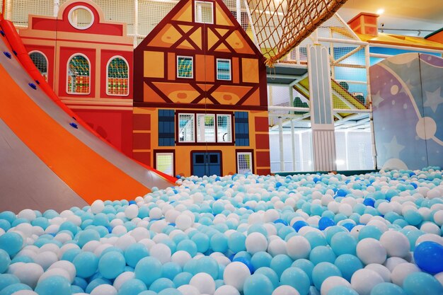 patio de recreo infantil cubierto con toboganes y bolas de plástico