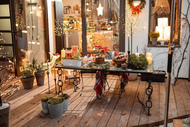 Patio trasero bellamente decorado de una casa de campo con una mesa festiva durante las vacaciones de Año Nuevo