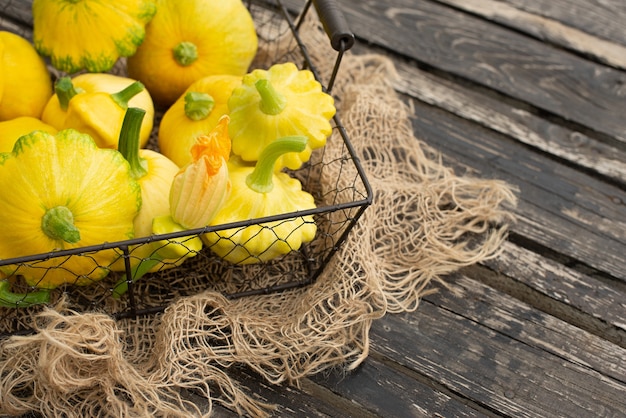 Patisson, Squash, calabaza en forma de plato, vegetales crudos sobre un fondo de madera oscura.