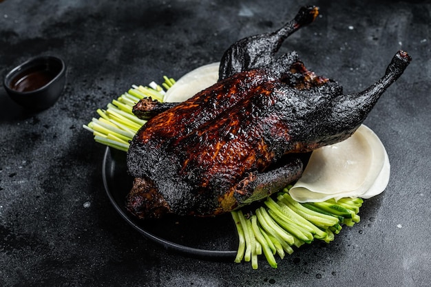 Pato à Pequim de Natal inteiro assado tradicional com ervas e molho Fundo preto Vista superior