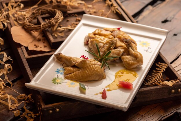 El pato amarillo en el largo plato blanco está en la mesa de madera