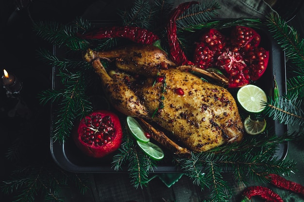 Pato de natal com romãs e limão cercado por galho de abeto