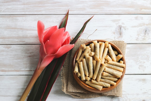 Foto pato frito delgado rollitos de primavera en la mesa de madera con flores.