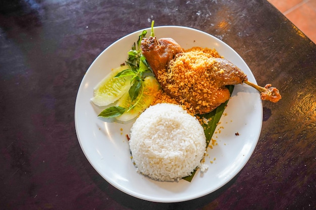 Pato frito servido con verduras frescas y salsa picante en un plato blanco