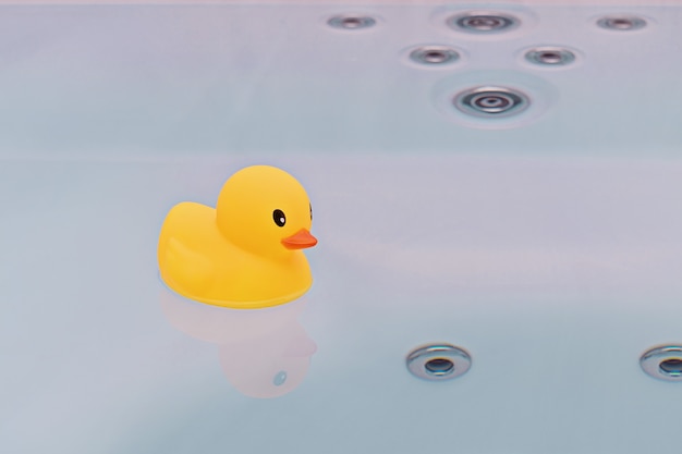 Pato de goma amarillo grande flotando en la bañera
