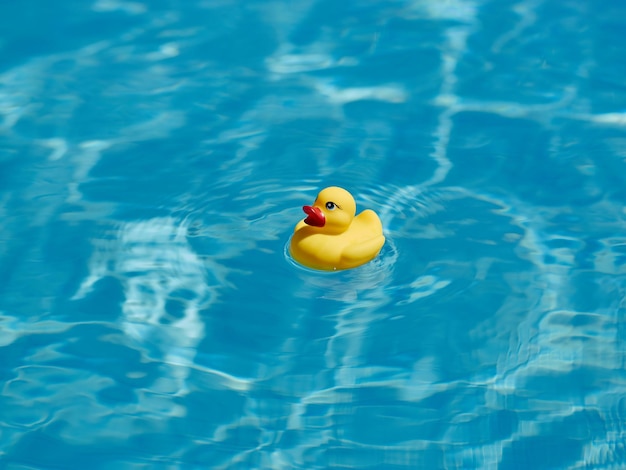 Pato de goma amarillo que flota en una piscina