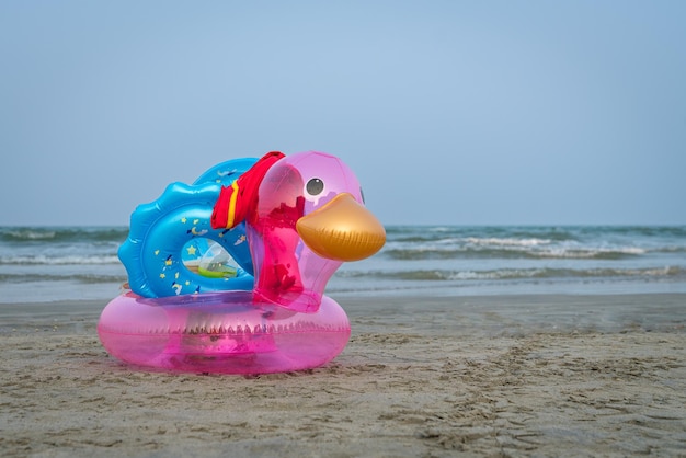 Pato inflable en una playa de arena Mar y cielo azul al fondo