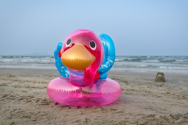 Pato inflable en una playa de arena Mar y cielo azul al fondo