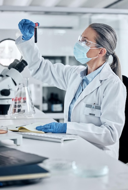 Patología científica y mujer científica de la sangre o el ADN que trabaja en un laboratorio para la innovación y la cura de la investigación covid con un tubo de ensayo de muestra Análisis y avance médico con una mujer de seguridad en el laboratorio