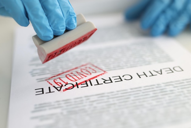 Patologista colocando carimbo vermelho na certidão de óbito closeup