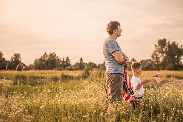 Patriotische Familie, die die amerikanische Flagge im Feld hält