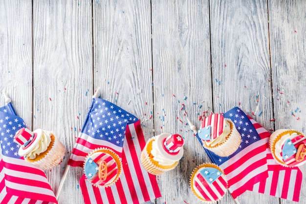 Patriotische usa cupcakes über flaggen auf holztisch