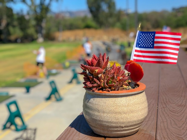 Patriotischer Blumentopf mit amerikanischen Flaggen und Golfer im Hintergrund Dekoration der amerikanischen Flagge