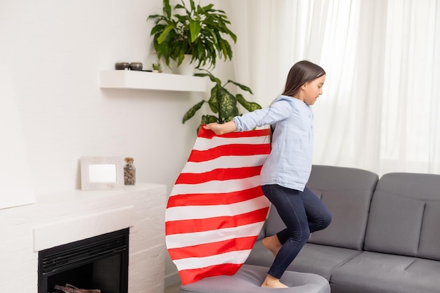 Patriotischer Feiertag. Glückliches Kind, süßes kleines Mädchen mit amerikanischer Flagge. Die USA feiern den 4. Juli.