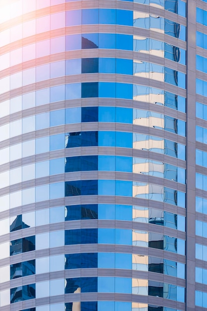 Patrón abstracto de la reflexión de los edificios de oficinas en la superficie de la pared de cristal azul del rascacielos