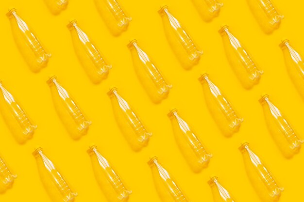 Patrón de botellas de plástico transparente sobre fondo amarillo Collage de fotos