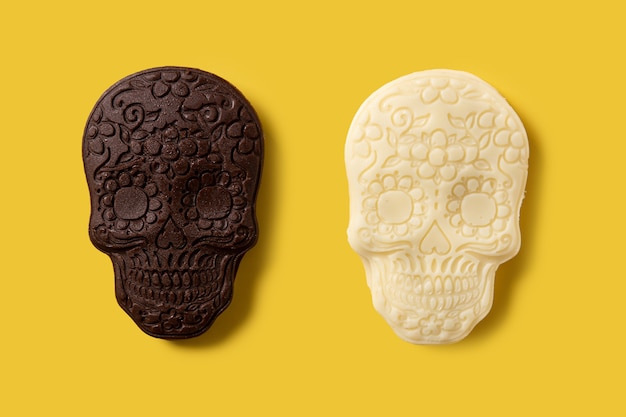 Patrón de calaveras mexicanas de chocolate sobre fondo amarillo