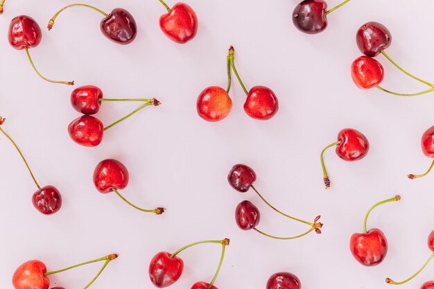 Patrón de cereza Plano de cerezas sobre un fondo rosaVista superior