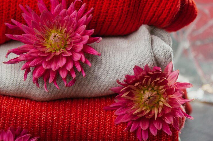 Foto patrón de coloridos suéteres de punto primer plano producto de lana merino hecho a mano una pila de ropa doblada con flores