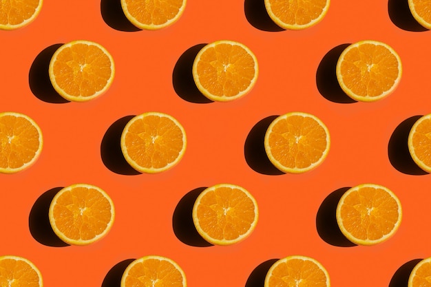 Patrón sin costuras de frutas naranjas maduras, sabrosas y jugosas sobre un fondo naranja brillante