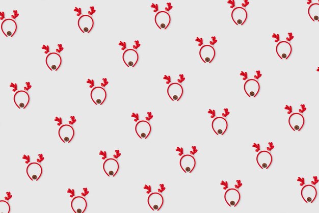 Patrón de cuernos rojos de Navidad de un ciervo con una piña en fondo blanco vista superior