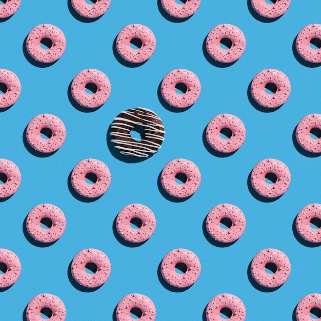 Patrón de donas dulces sobre un fondo azul.