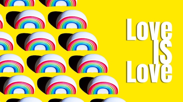 Patrón de la figura de un arco iris sobre un fondo amarillo con las palabras Love is Love impresas en él Concepto de amor LGBT