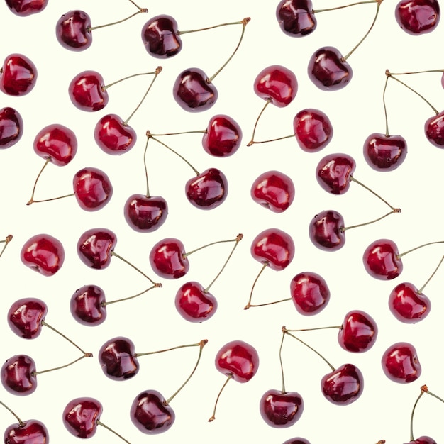 Foto patrón sin fin sin fisuras de cerezas dulces rojas maduras brillantes, aislado sobre fondo blanco.