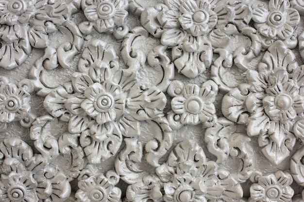 Patrón de flor gris tallada en estuco de pared nativa