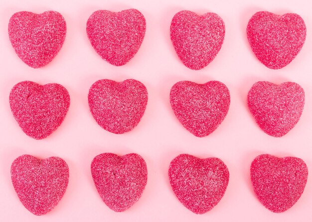 Patrón de forma de corazón de caramelo sobre fondo rosa