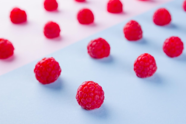 Patrón de frambuesas en fondo azul rosado Dieta colorida y concepto de alimentos saludables