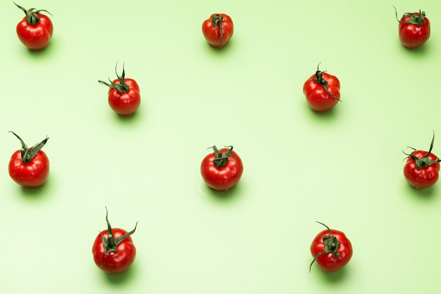 Patrón geométrico de tomates rojos sobre fondo verde Flat Lay Design