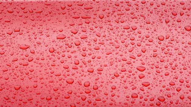 Patrón de gotas de agua de una superficie lisa pintada de rojo