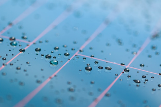 Patrón de gotas de agua en una superficie metálica brillante con reflejos de mesa