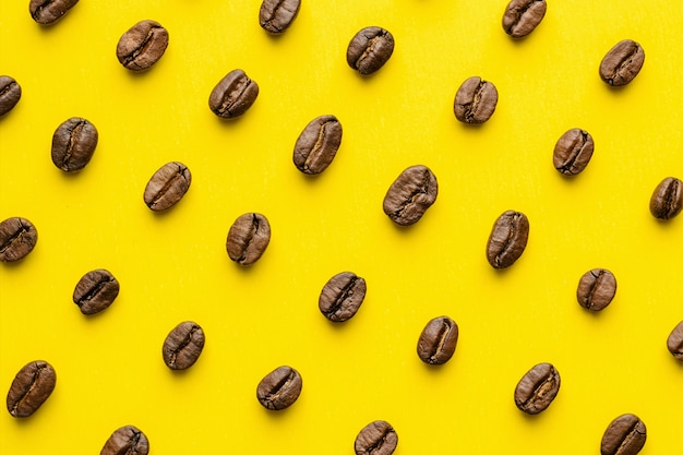 Patrón de granos de café sobre fondo amarillo