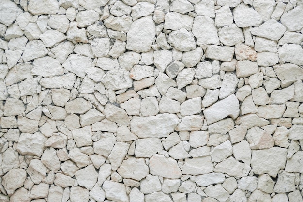 Foto patrón de grietas decorativas desiguales de la superficie de la pared de piedra real con color pastel claro y estilo moderno concepto de interior y arquitectura