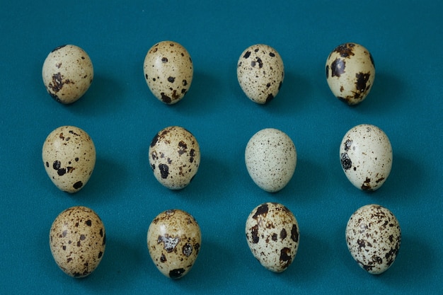 Foto patrón de huevos de codorniz sobre un fondo verde. conjunto de huevos de codorniz