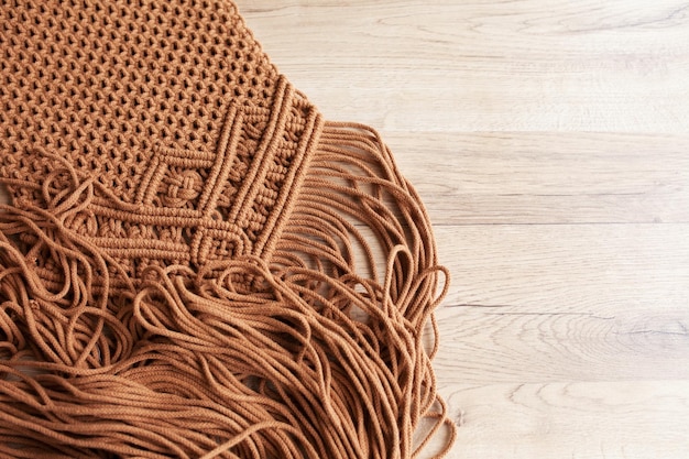 Patrón de macramé hecho a mano de cerca Trenzado de macramé e hilos de algodón sobre mesa de madera Hobby femenino Ecológico moderno concepto de decoración natural de bricolaje en el interior Espacio de copia