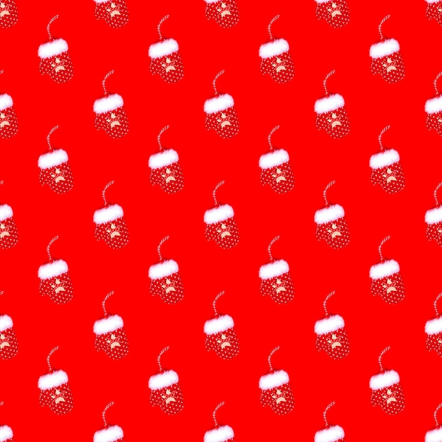 Foto patrón de navidad de guantes en un fondo rojo concepto de vacaciones de año nuevo