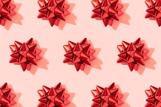 Patrón navideño creativo con lazo rojo sobre fondo rosa de vacaciones de Navidad