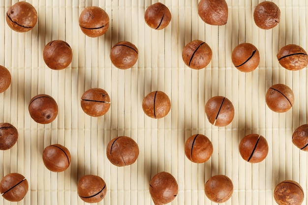 Patrón de nueces de macadamia sobre un fondo de bambú