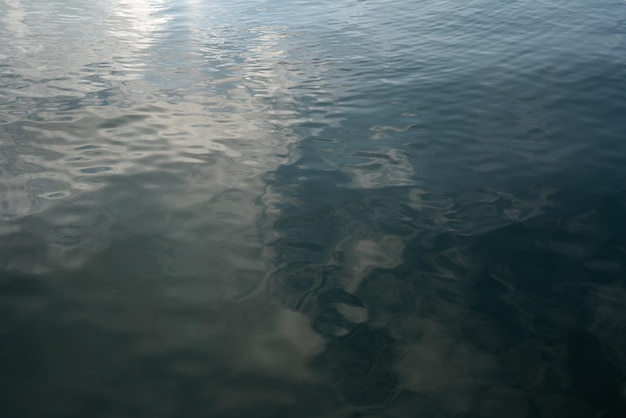 Patrón de onda borrosa. Primer plano de la superficie del agua del mar. Nubes reflejadas en el agua