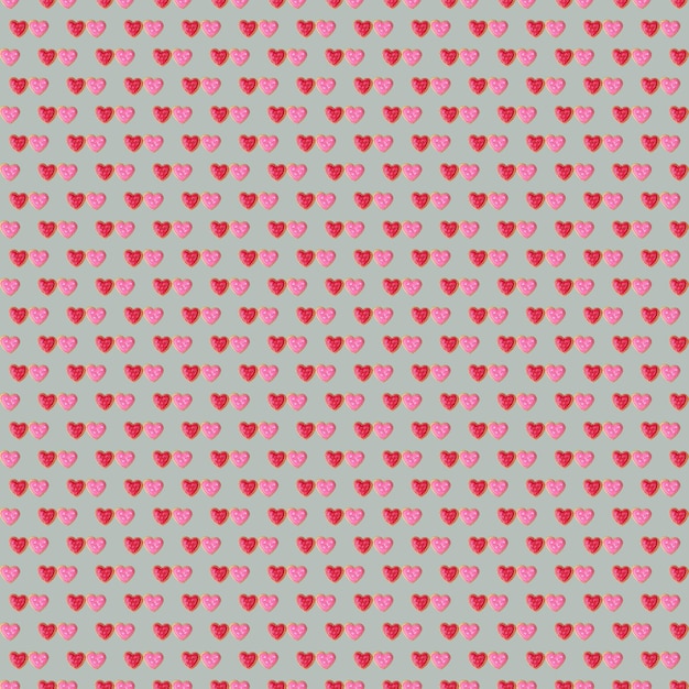 Patrón de un par de galletas de hielo real en forma de corazón rojo y rosa sobre fondo gris nube