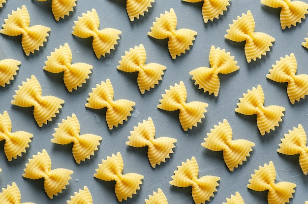 Patrón de pasta Farfalle sobre un fondo azul claro.