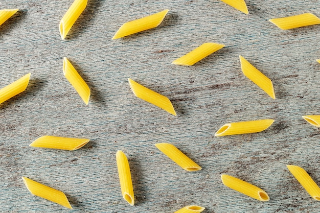 Patrón de una pasta penne sobre un fondo de madera gris